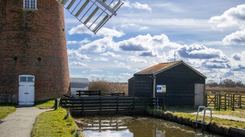 Image showing the view looking towards Horsey Windpump with the staithe and electric pumping station to the right which is housed in a painted black wooden shed like structure